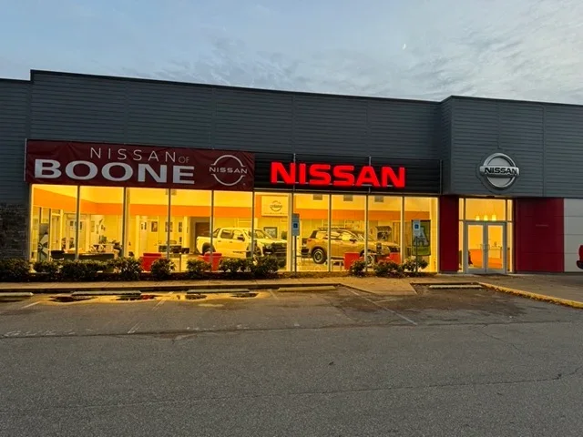 lineup of nissan models in front of dealership